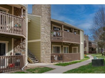 Charming apartment exterior featuring private balconies, stone accents, and well-maintained landscaping at 3414 S Eagle St # 201, Aurora, CO 80014