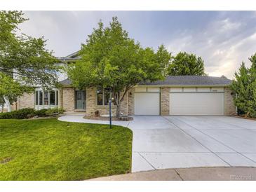Charming two-story brick home with a well-maintained lawn, mature trees, and a spacious three-car garage at 5723 S Kittredge St, Centennial, CO 80015