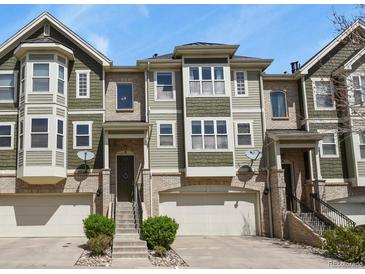 Exterior view of townhomes with brick and siding, garages, and landscaped entrances on a sunny day at 3680 S Beeler St # 5, Denver, CO 80237