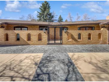 An elaborate brick facade featuring a gated entrance and meticulously designed concrete driveway at 4365 S Alton Way, Greenwood Village, CO 80111
