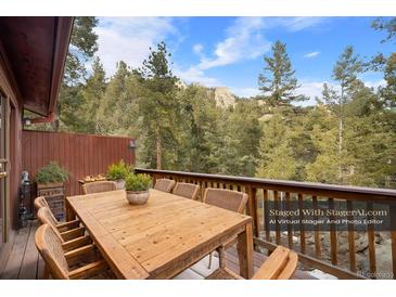 Outdoor dining on the deck with a stunning view of the surrounding landscape at 25531 Mosier Cir, Conifer, CO 80433