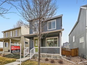Charming two-story home with blue siding, white trim, a green front door and a quaint front porch at 4723 Crestone Peak St, Brighton, CO 80601
