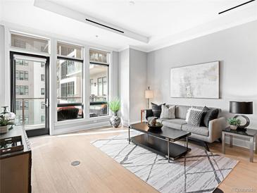 Bright living room boasts floor-to-ceiling windows and access to a private balcony with outdoor seating at 7600 Landmark Way # 914, Englewood, CO 80111