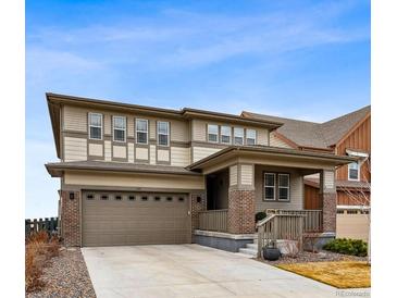 Inviting two-story home featuring a covered front porch and attached two-car garage at 1669 Stable View Dr, Castle Pines, CO 80108