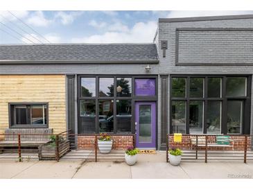 Charming building exterior with a purple door, decorative planters, and brick accents at 1810 E 33Rd Ave, Denver, CO 80205
