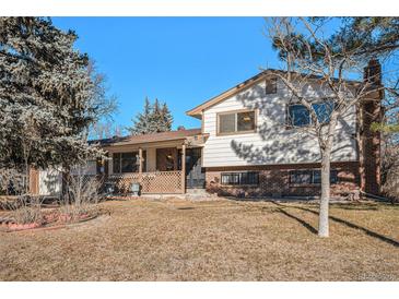 Ranch style home with brick and siding exterior, mature trees, and a well-maintained lawn at 11050 Melody Dr, Northglenn, CO 80234