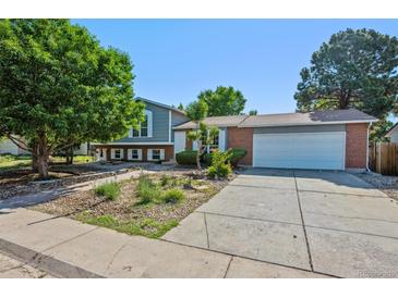 Charming home with a blend of brick and siding, complemented by a well-maintained yard and mature trees at 9222 Albion St, Thornton, CO 80229