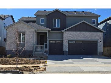 Charming two-story home features a two-car garage and a stone and gray siding exterior at 2488 Wesley Ln, Lafayette, CO 80026