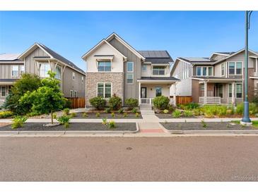 Charming two-story home featuring stone accents, a front porch, and solar panels at 10295 E 59Th Ave, Denver, CO 80238
