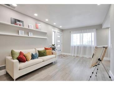 Bright living room with comfy sofa and large window at 9195 E Lehigh Ave # 151, Denver, CO 80237