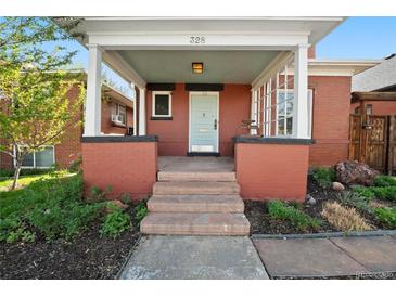 Charming red brick home featuring a covered front porch with an inviting entryway and well-manicured landscaping at 328 S Lincoln St, Denver, CO 80209