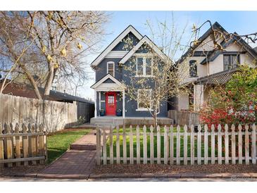 Charming two-story home with a red door, complemented by a brick walkway and white picket fence at 3142 W 26Th Ave, Denver, CO 80211