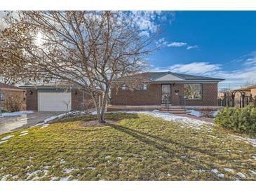 Brick ranch home with attached garage and landscaped yard at 942 Leroy Dr, Northglenn, CO 80233