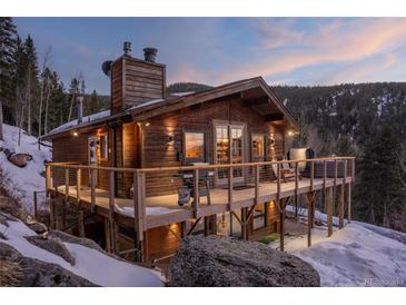 Charming wooden cabin with a spacious deck and stunning mountain views, perfect for enjoying the outdoors at 32094 Christopher Ln, Conifer, CO 80433