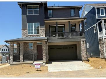 Inviting two-story home with a stone facade, a balcony, and a spacious two-car garage at 6717 E 149Th Ave, Thornton, CO 80602