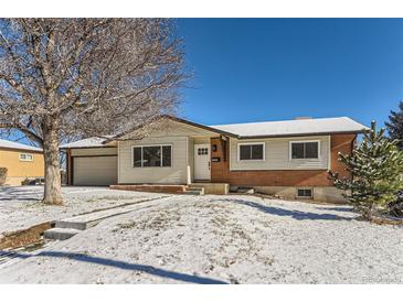 Ranch style home with brick and siding accents, snow covered yard at 994 S Vivian Ct, Lakewood, CO 80228