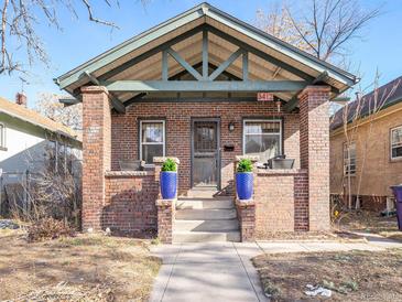 Brick home with a classic front porch and landscaping at 3412 Zuni St, Denver, CO 80211