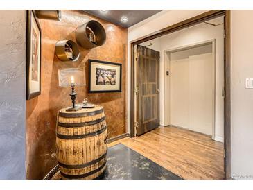 Charming hallway featuring a decorative barrel table, unique wall decor, and convenient elevator access at 1735 19Th St # 5B, Denver, CO 80202