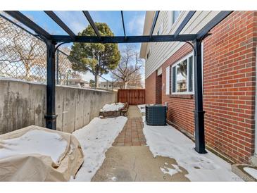 Cozy backyard patio area with brick flooring, pergola and privacy fence, perfect for outdoor relaxation at 9886 Appletree Pl, Thornton, CO 80260