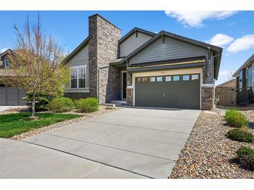 Charming home with a stone chimney, three-car garage, and well-manicured front yard at 3429 Goodyear St, Castle Rock, CO 80109