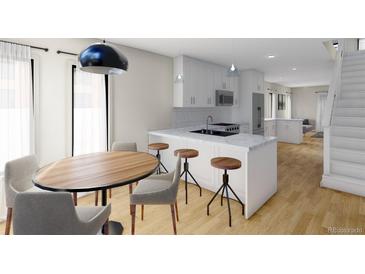 Bright and airy kitchen with island, modern appliances, and eat-in dining area at 115 W 2Nd Ave # 104, Denver, CO 80223