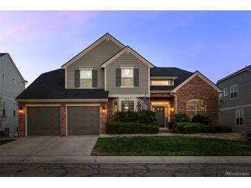 Charming two-story home featuring a three car garage, brick accents and a beautifully landscaped front yard at 7862 Stonedale Dr, Castle Pines, CO 80108
