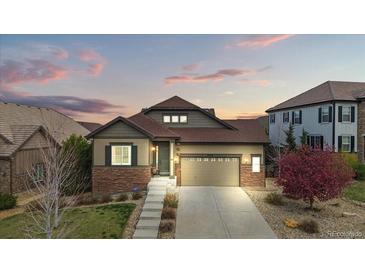 Charming single-Gathering home with brick accents, a well-manicured lawn, and a two-car garage at 7790 S Queensburg Way, Aurora, CO 80016