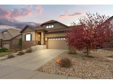 Beautifully landscaped front yard with a stone driveway leading to the attached two-car garage at 7790 S Queensburg Way, Aurora, CO 80016