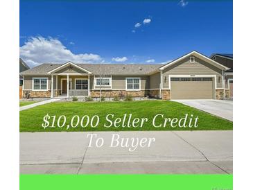 Charming single-story home featuring a well-manicured lawn, inviting porch, and an attached two-car garage at 56375 E 22Nd Pl, Strasburg, CO 80136