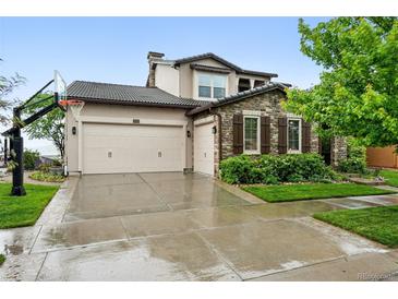 Charming two-story home featuring a three-car garage, stone accents and a basketball hoop at 15377 W Iliff Dr, Denver, CO 80228