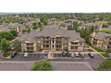 Attractive condo building with a parking lot and balconies nestled within lush landscaping and mature trees at 7413 S Quail Cir # 1435, Littleton, CO 80127
