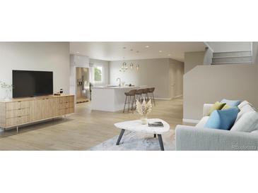 Bright, open living room featuring wood floors, a modern kitchen, and comfortable seating for relaxing and entertaining at 9061 E 14Th St, Aurora, CO 80010