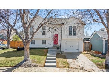 Charming two-story home with a white exterior, red door, and landscaped front yard at 19792 E Bates Dr, Aurora, CO 80013