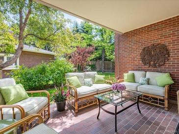 Comfortable covered brick patio with ample seating and verdant landscaping creates an inviting outdoor retreat at 2552 E Alameda Ave # 16, Denver, CO 80209