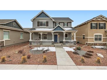 Charming two-story home with a covered front porch and landscaped front yard at 668 Sage Forest Ln, Monument, CO 80132