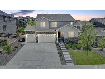 Charming two-story home with a three car garage, stone accents, landscaped front yard and long driveway at 6630 S Coolidge Ct, Aurora, CO 80016