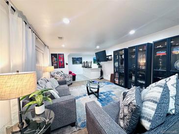 Open living room featuring neutral walls, cozy couches, modern lighting, and stylish decor at 9411 Rose Ct, Thornton, CO 80229