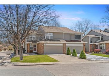 Inviting townhome with a well-manicured lawn, two-car garage, and brick accents on a tree lined street at 1550 S Syracuse St, Denver, CO 80231