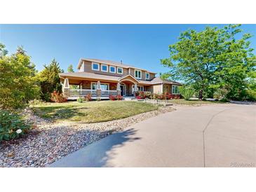 Beautiful home showcasing a covered front porch, stone accents, and mature landscaping at 9353 E 146Th Ave, Brighton, CO 80602