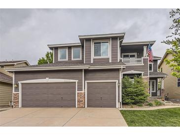 Two-story home featuring a two-car garage, stone accents, and a second story balcony at 10230 Lauren Ct, Highlands Ranch, CO 80130