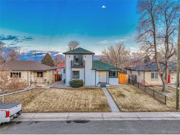 Charming two-story home with a balcony and a well-manicured front yard under a beautiful blue sky at 3550 Eudora St, Denver, CO 80207