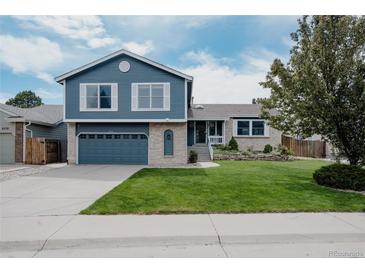 Charming two-story home features a well-manicured lawn, attached garage, and classic blue siding at 6386 S Pierson St, Littleton, CO 80127
