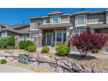 Beautiful townhome with a stone exterior, landscaping, and a well-maintained front yard at 4887 Raven Run, Broomfield, CO 80023
