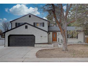 Charming two-story home featuring a brick exterior, a well-manicured lawn, and a two-car garage at 7249 S Iris Ct, Littleton, CO 80128