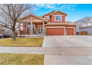 Inviting two-story home with a spacious three-car garage and a charming front porch at 16160 E 119Th Ave, Commerce City, CO 80022