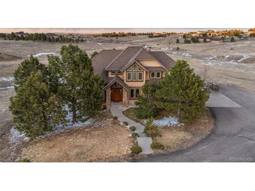 Expansive home with a manicured front lawn and large trees, offering substantial curb appeal at 47032 Frasier Fir Cir, Parker, CO 80138