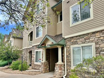 Inviting condo exterior featuring stone accents, neutral siding, and well-maintained landscaping at 9390 W Chatfield Pl # 103, Littleton, CO 80128