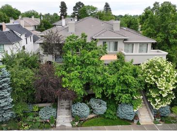 Stunning two-story home featuring lush landscaping, dual staircases, and a serene balcony at 458 Adams St, Denver, CO 80206
