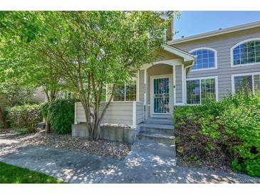 Charming home featuring a covered front entrance, lush landscaping and a secure storm door at 4006 E Geddes Cir, Centennial, CO 80122