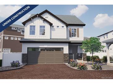 Charming two-story home featuring stone accents, a two-car garage, landscaped yard, and an inviting front entrance at 1212 Sugarloaf Ln, Erie, CO 80516